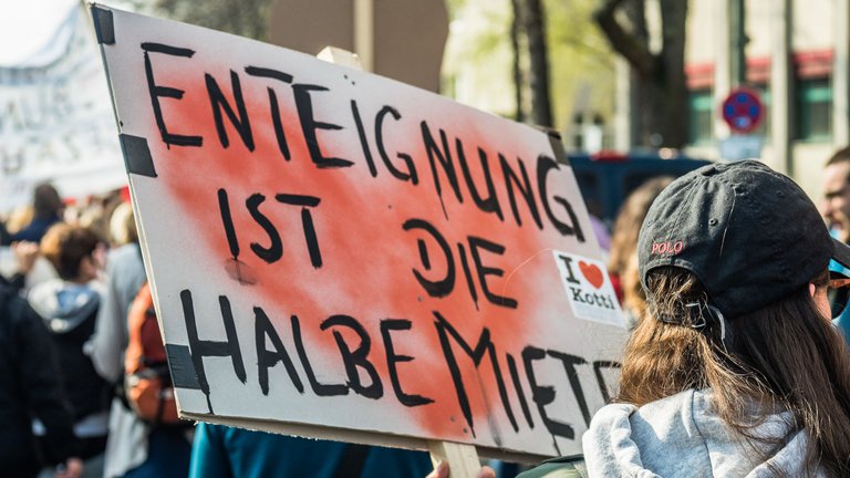 Protestplakat mit der Aufschrift "Enteignung ist die halbe Miete"